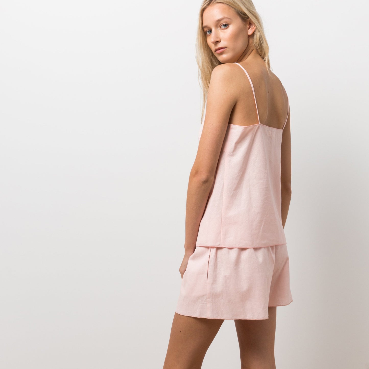 Woman wearing pink cami and shorts