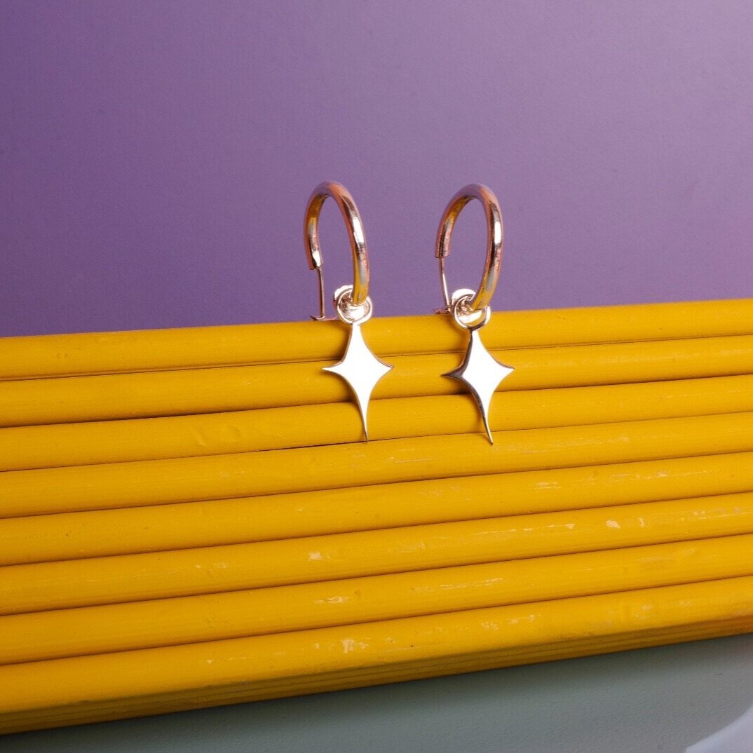 Small hoop earrings with a star shaped charm 