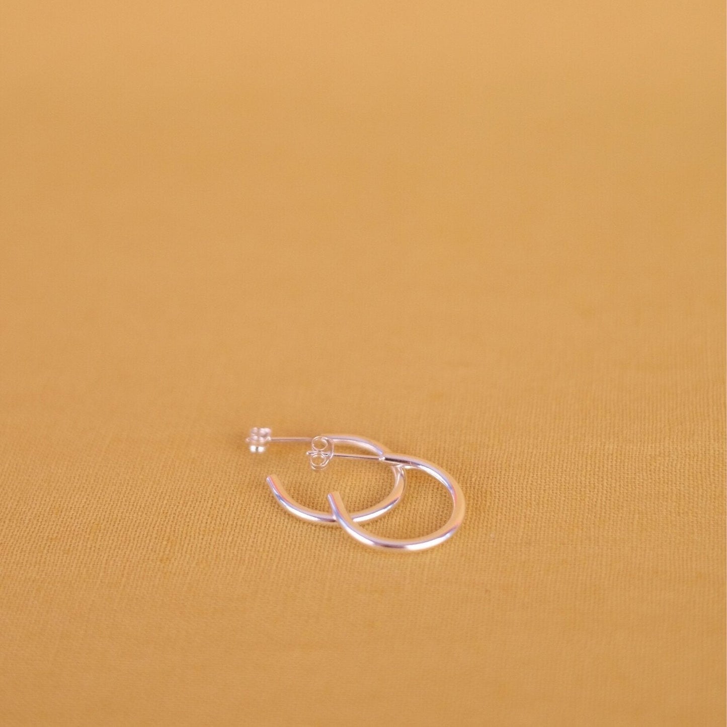 Close up of small silver hoop earrings
