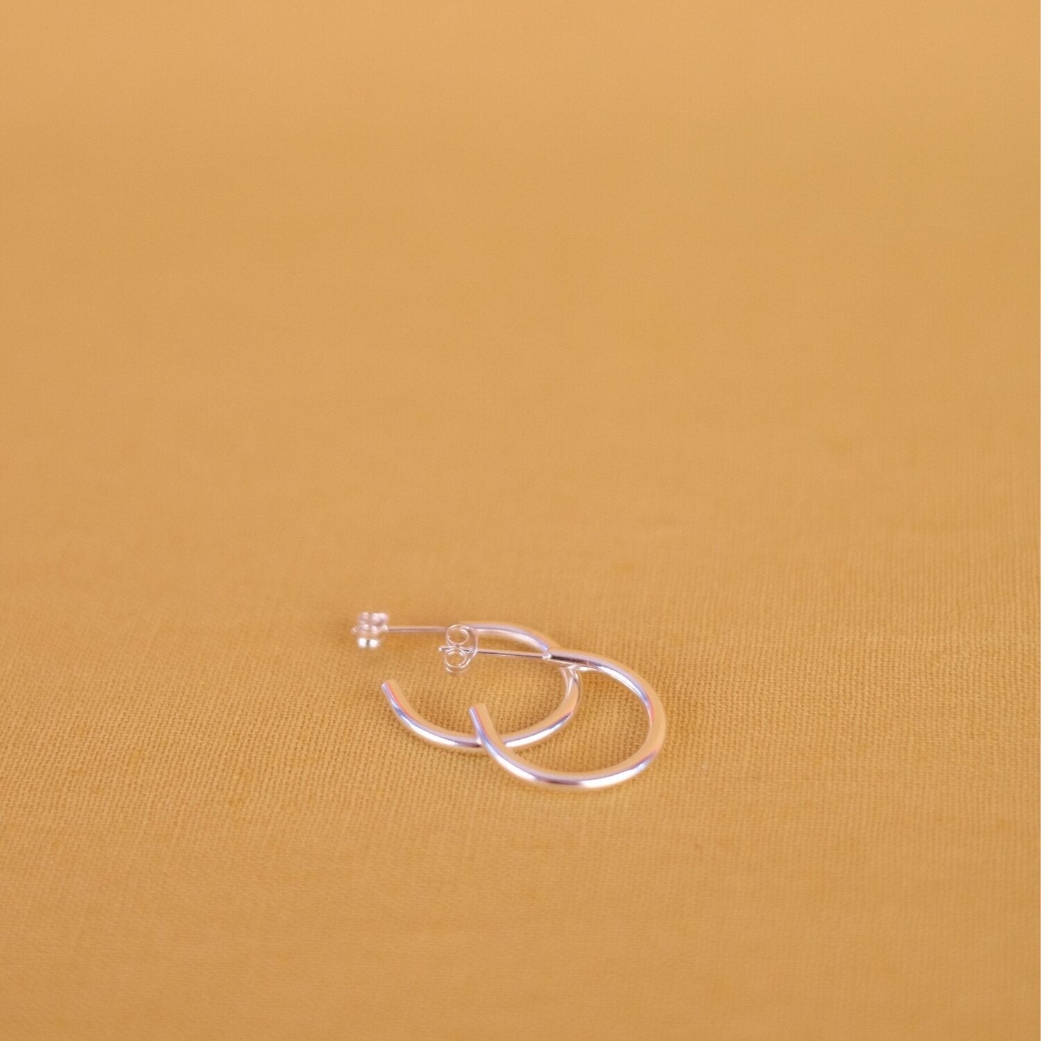 Close up of small silver hoop earrings